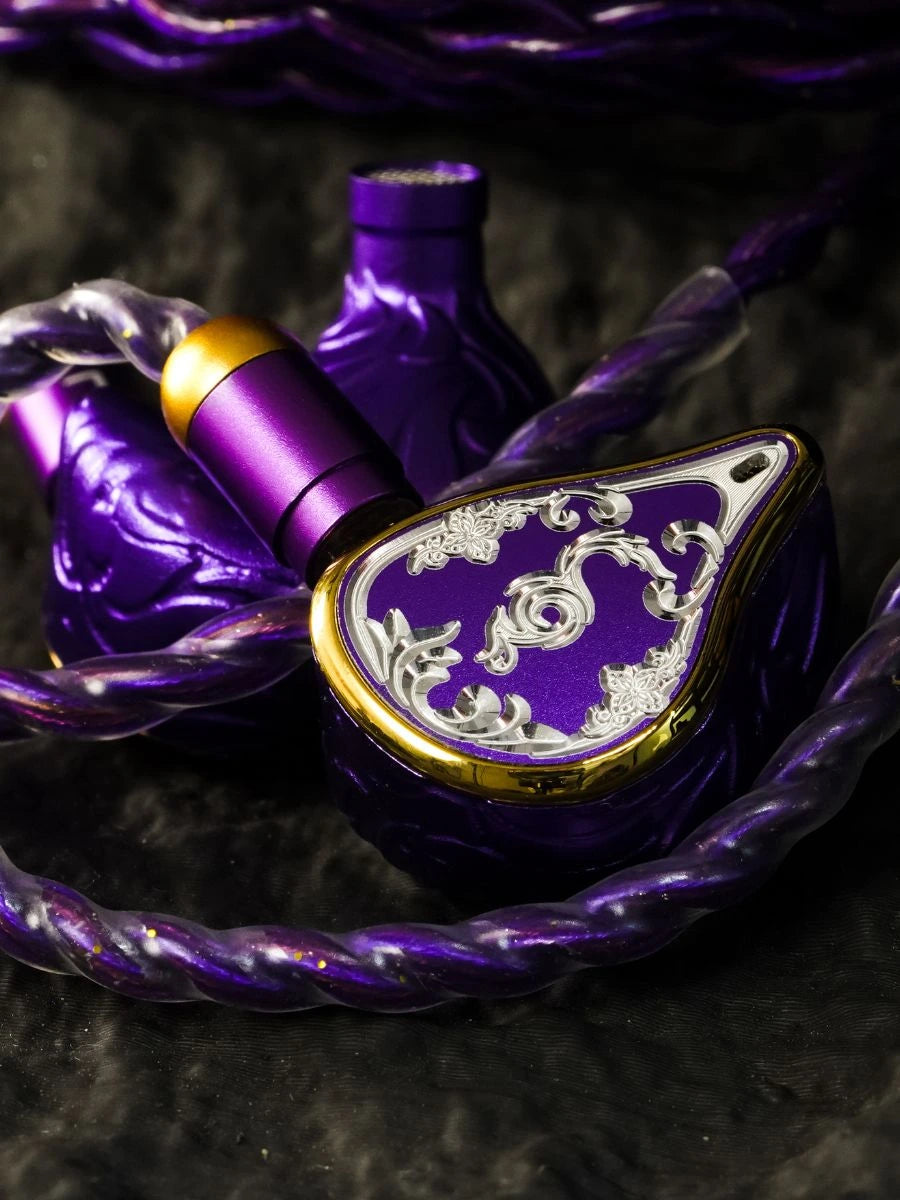 Purple and silver 1IA in-ear headphones with a gold accent, resting on a dark textured surface with a matching purple braided cable.