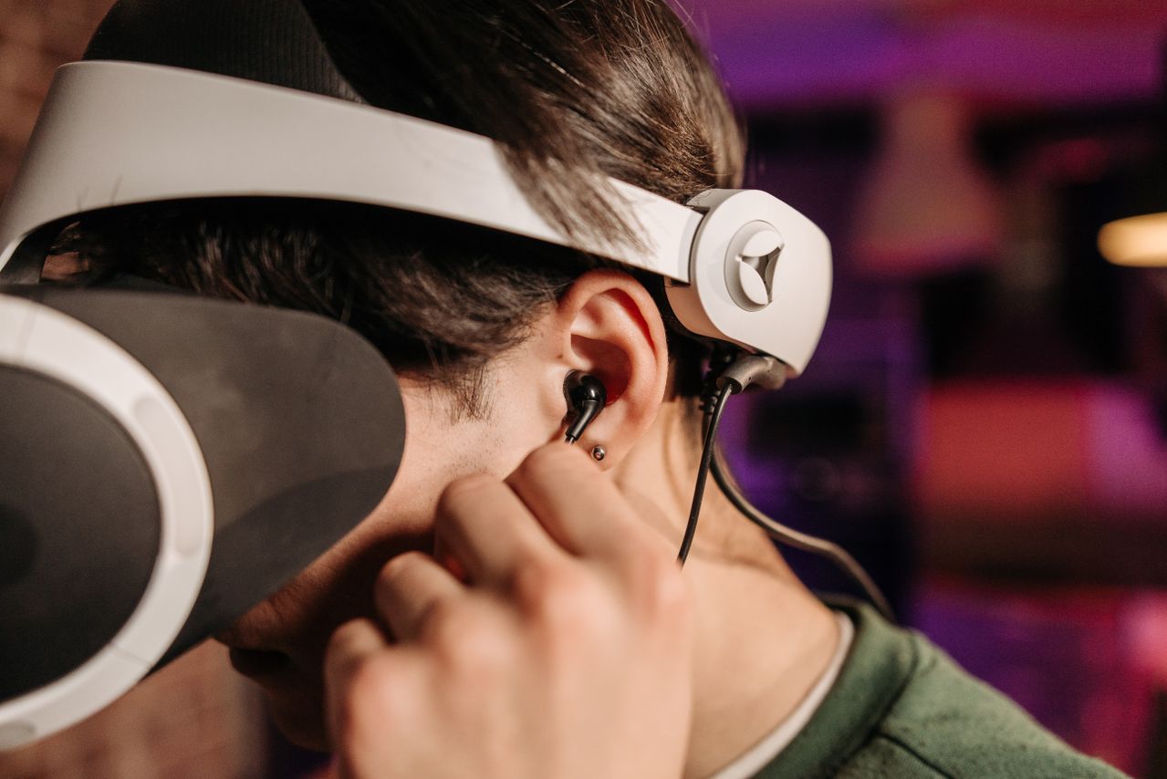 Gaming IEM worn beneath an esports isolation headset during competitive play